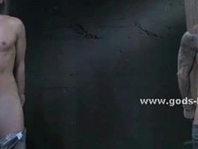 Muscular gay men engage in BDSM activities with bondage and leather equipment.